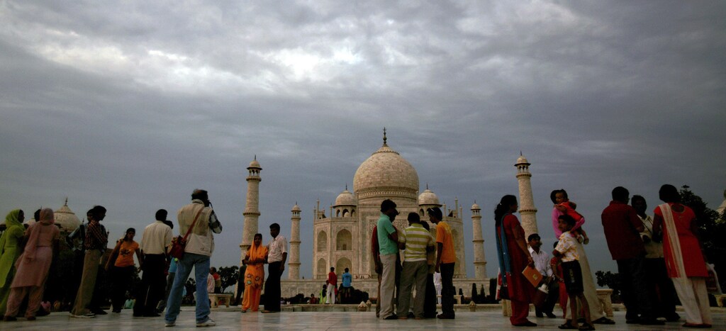 Tourists stand in front of the historic Taj Mahal in the northern Indian city of Agra July 11, 2007