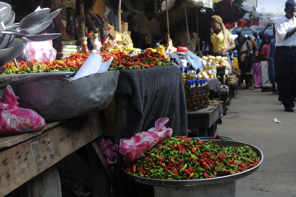 Women sell vegetables in a market in Monrovia, Liberia, October 1, 2014. The threat of hunger is tracking Ebola across affected West African nations as the disease kills farmers and their families, drives workers from the fields and creates food shortages. Picture taken October 1, 2014. REUTERS/James Giahyue (LIBERIA - Tags: HEALTH DISASTER FOOD) - GM1EAA3097U01