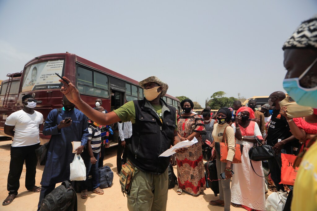 Senegalese teachers wait to board government-chartered buses taking them to rural schools.