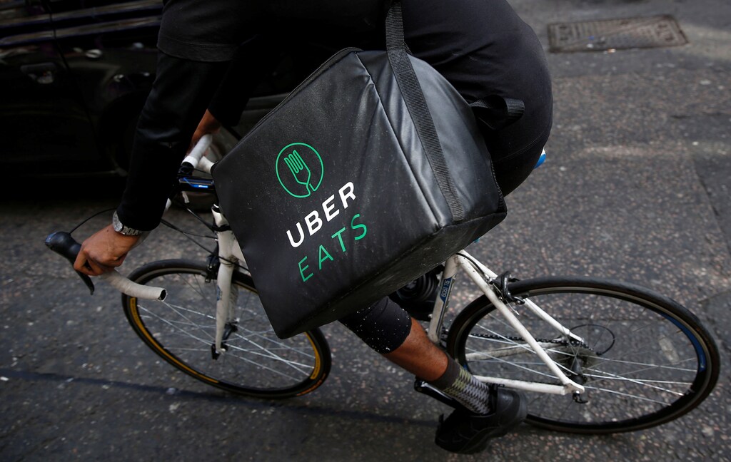 An Uber Eats food delivery courier rides his bike in London.