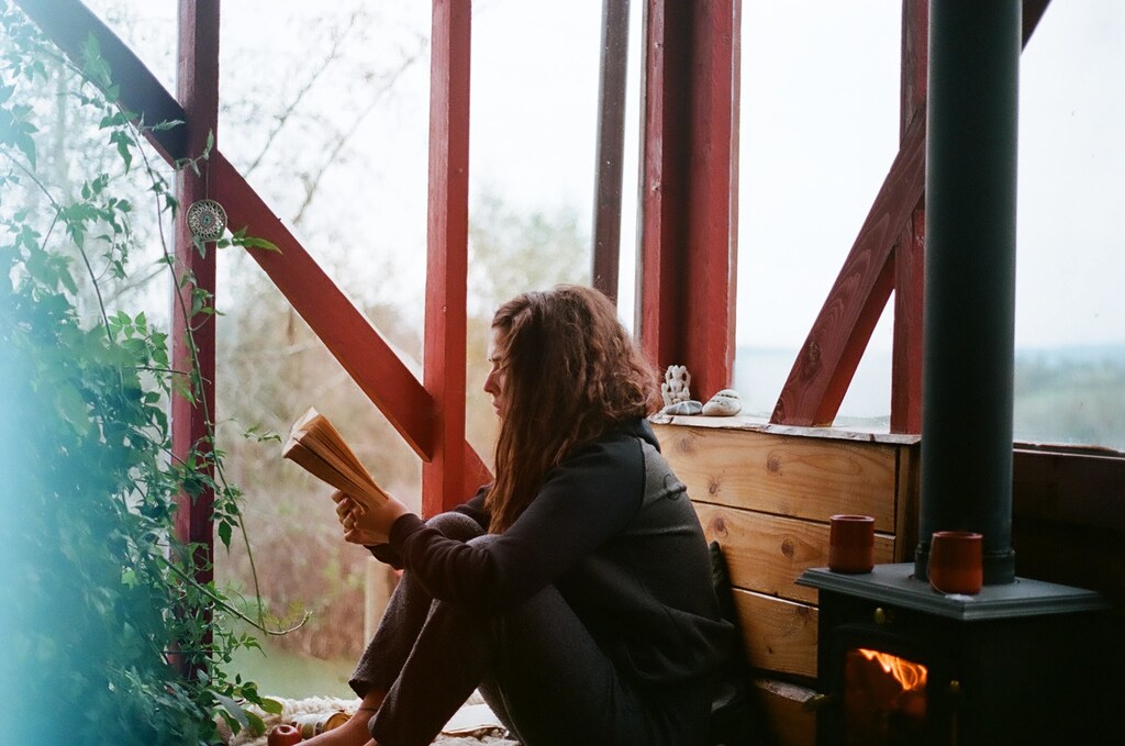 this woman is reading a printed book; printed books are still currently more popular than e-books.