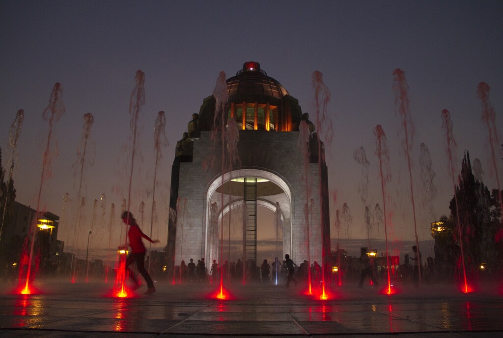 A child runs through a fountain at the Monument of the Revolution in Mexico City.