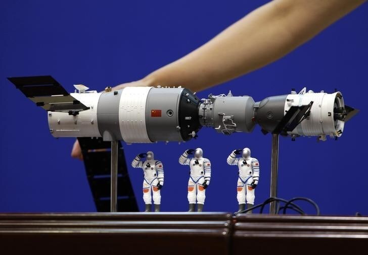 A model of the Shenzhou-9 manned spacecraft ( R) docking with the orbiting Tiangong-1 space lab module (L) and three Chinese astronauts is displayed during a news conference at Jiuquan Satellite Launch Center, in northwest China's Gansu province, June 15, 2012. The Shenzhou-9 manned spacecraft will be launched at 18:37 (10:37 GMT) on June 16, 2012, according to a decision made by China's manned space docking program headquarters, Xinhua News Agency reported. REUTERS/Jason Lee (CHINA - Tags: SCIENCE TECHNOLOGY)