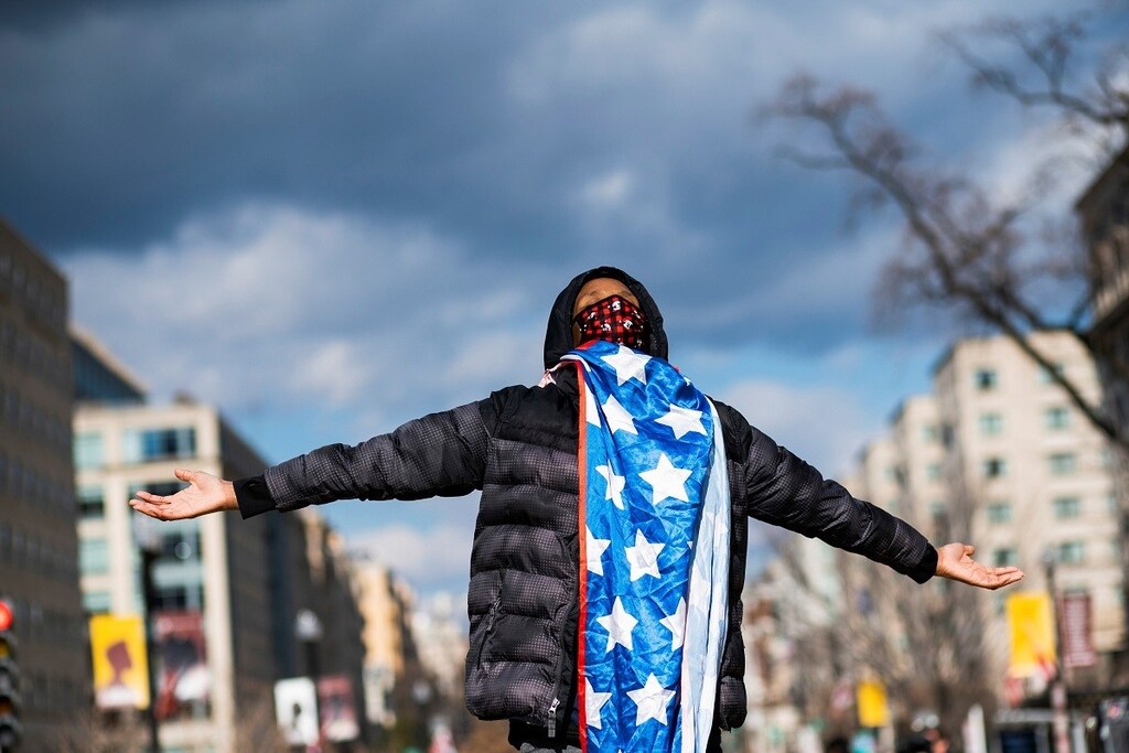 A supporter of U.S. President Joe Biden celebrates after he was sworn in as the 46th President of the United States, at Black Lives Matter Plaza, in Washington D.C., U.S. January 20, 2021. REUTERS/Eduardo Munoz - RC2UBL92OD1B