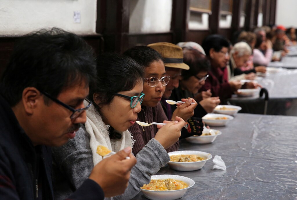 People eat soup called 'porciuncula' during La Porciuncula, a religious activity where Franciscan priests give food to people, at the convent of Los Descalzos, in Lima, Peru, August 2, 2017. REUTERS/Mariana Bazo - RC1D82BDF190
