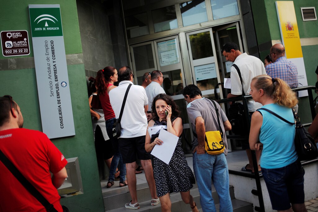 A woman uses her mobile phone as she leaves from a government-run job centre in Malaga, Spain, July 4, 2016. REUTERS/Jon Nazca - RTX2JKRK