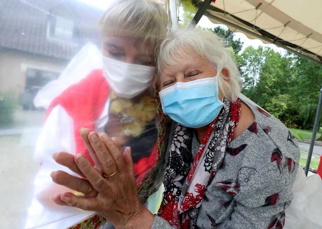 Lily Hendrickx, 83, a resident at Belgian nursing home "Le Jardin de Picardie" enjoys hugs and cuddles with Marie-Christine Desoer, the director of the residence, through a wall made with plastic sheets to protect against potential coronavirus disease (COVID-19) infection, in Peruwelz, Belgium, July 1, 2020. REUTERS/Yves Herman/File Photo TPX IMAGES OF THE DAY SEARCH "GLOBAL COVID-19" FOR THIS STORY. SEARCH "WIDER IMAGE" FOR ALL STORIES. - RC2NFK9YYM8J