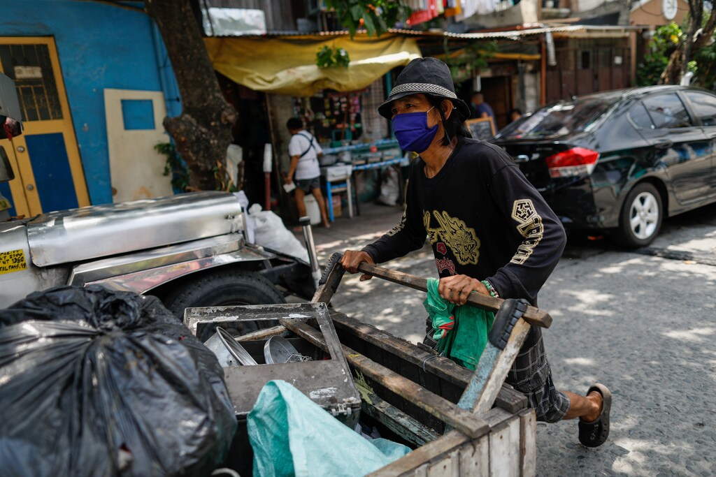 Waste picker Virgilio Estueta, 60, walks with his cart filled with trash amid the coronavirus disease (COVID-19) outbreak, in Quezon City, Metro Manila, Philippines, July 7, 2020. Picture taken July 7, 2020