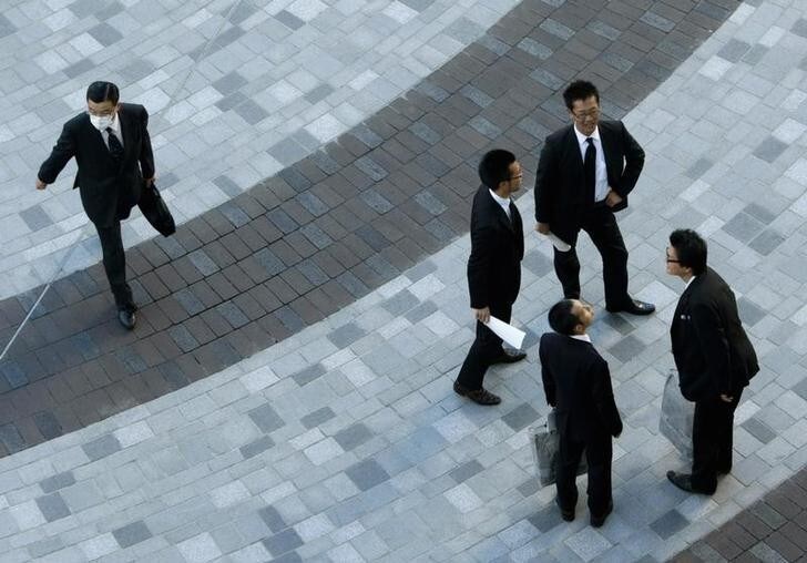 Businessmen stand on a street in Tokyo November 13, 2007. Japan's economy grew more than expected in the third quarter, as firm exports and capital spending helped avert a recession, but the growth was not enough to alter expectations the Bank of Japan will keep rates on hold till next year. REUTERS/Issei Kato (JAPAN)