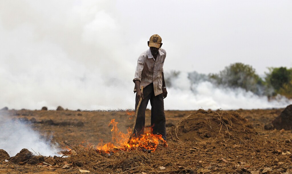 A farmer burns dried grass and twigs on his field near the proposed site of the Jaitapur nuclear plant in Ratnagiri district, about 360 km (224 miles) south of Mumbai, April 13, 2011. Farmers burn dried grass and twigs on the land before the planting season to introduce ash to the soil, a traditional method of increasing soil fertility. REUTERS/Danish Siddiqui (INDIA - Tags: ENVIRONMENT ENERGY) - GM1E74D1EXK02