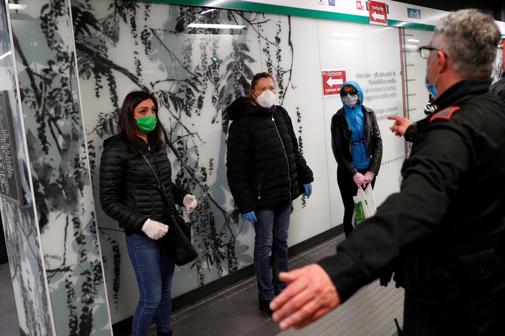 Un guardia de seguridad del metro hace un gesto mientras la gente se para en señales de distanciamiento social mientras esperan un tren en la estación de metro de San Giovanni mientras continúa la propagación de la enfermedad coronavirus (COVID-19), en Roma, Italia, el 28 de abril de 2020.