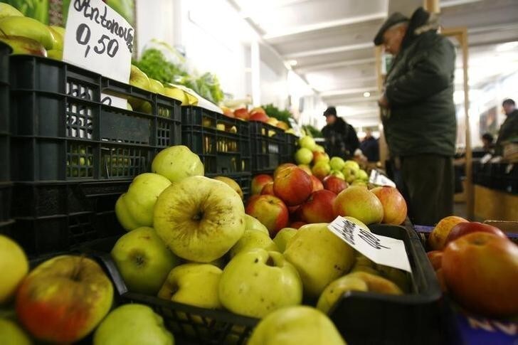 People shop in a market in Riga February 19, 2009. More and more farmers are starting to sell their products direct to the public in local markets in order to get a better price as their incomes have collapsed during the financial crisis. Farmers also want to avoid using the supermarket chains and food processors, which drive their prices down. REUTERS/Ints Kalnins (LATVIA)