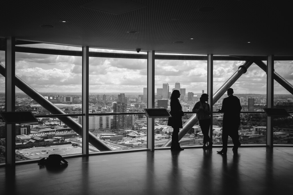 Silhouette of three people in a high rise office with a view: The family business has embedded purpose as it prioritizes succession, value and legacy.