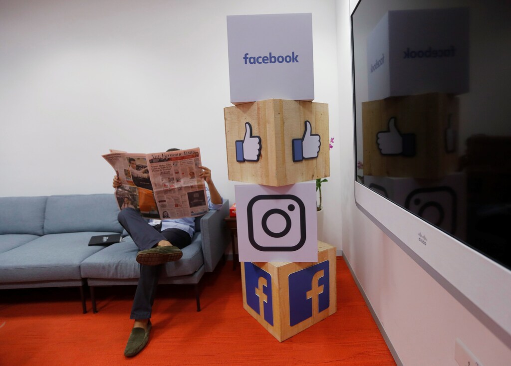 A man reads a newspaper at the reception area of Facebook's new office in Mumbai, India May 27, 2016. REUTERS/Shailesh Andrade - RTX2EGEK