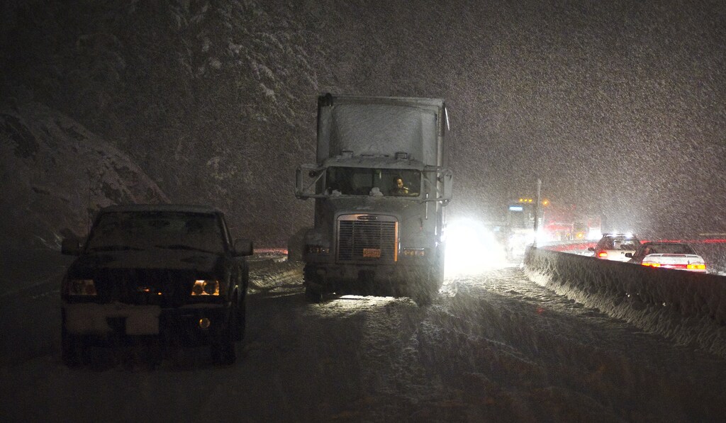 A truck driver sits in this cab sits after a heavy snow storm closed the Sea to Sky Highway south of Squamish, British Columbia February 17, 2011. The Royal Canadian Mounted Police closed the road for several hours after the storm and snow made driving treacherous on the mountain roads north of Vancouver
