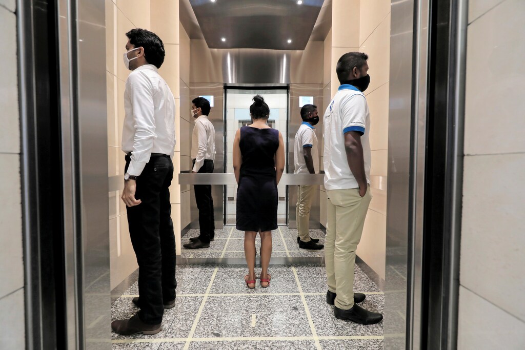 People practice social distancing inside an elevator prior to arriving to their work places at World Trade Center, after the government announced that private and state companies will reopen their offices after almost two months of lockdown amidst concerns about the spread of coronavirus disease (COVID-19) in Colombo, Sri Lanka May 11, 2020. REUTERS/Dinuka Liyanawatte TPX IMAGES OF THE DAY - RC29MG9B5S3U