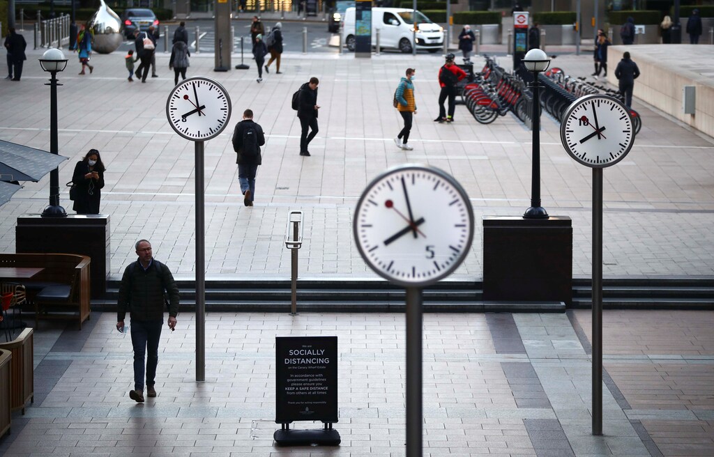 People walk during the morning rush hour in the Canary Wharf amid the outbreak of the coronavirus disease (COVID-19) in London Britain, October 15, 2020. REUTERS/Hannah McKay - RC2VIJ9GREF3