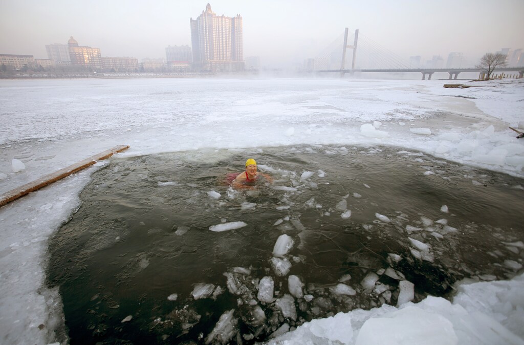A winter swimmer swims in icy waters after breaking the ice of the frozen Songhua River, in Jilin, Jilin province February 11, 2015. REUTERS/Stringer (CHINA - Tags: ENVIRONMENT SPORT SWIMMING TPX IMAGES OF THE DAY) CHINA OUT. NO COMMERCIAL OR EDITORIAL SALES IN CHINA - GM1EB2B130K01
