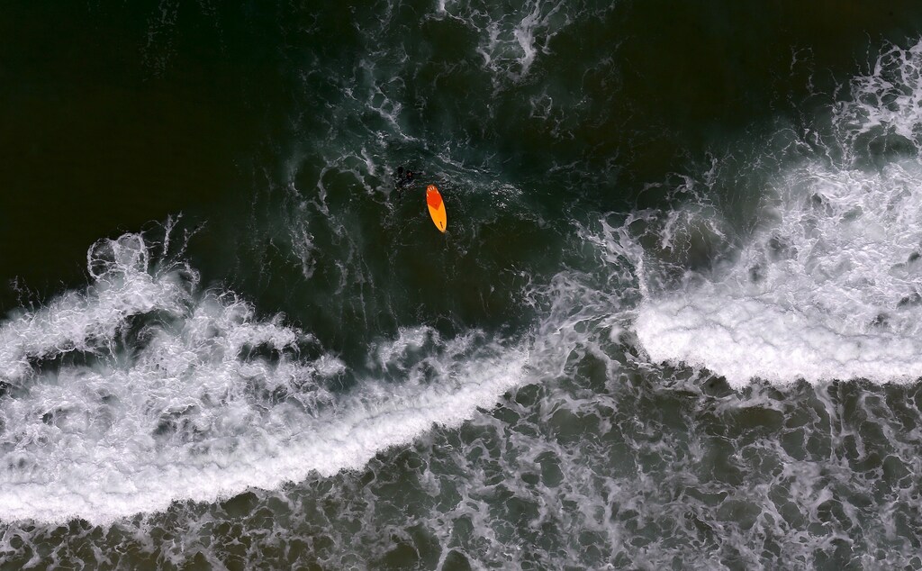 A surfer swims at Barra da Tijuca beach in Rio de Janeiro, Brazil July 29, 2015. REUTERS/Ricardo Moraes TPX IMAGES OF THE DAY - GF20000008173