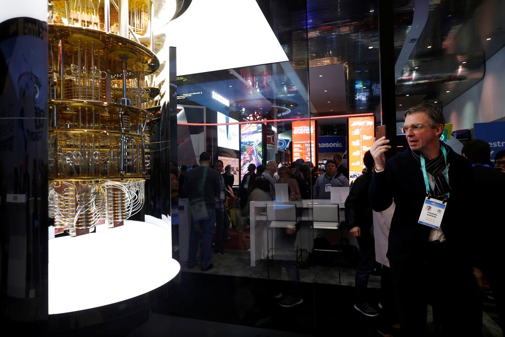 A man takes a photo of the IBM Q System One quantum computer.