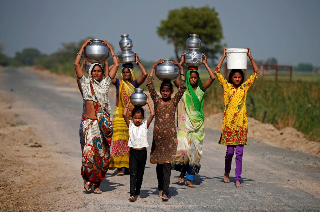 Village women and girls carry water at Fangadi Village on the outskirts of Ahmedabad, India January 27, 2018. Picture taken January 27, 2018. REUTERS/Amit Dave - RC1BD1AA0E40
