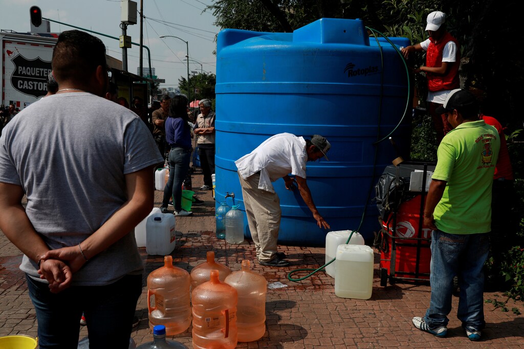 Residents queue to fill their containers from a water tank as free distribution of water takes place days after water supply was cut due to delays in maintenance tasks in a segment of the Cutzamala System in Mexico City, Mexico November 7, 2018. REUTERS/Carlos Jasso - RC13738A6590