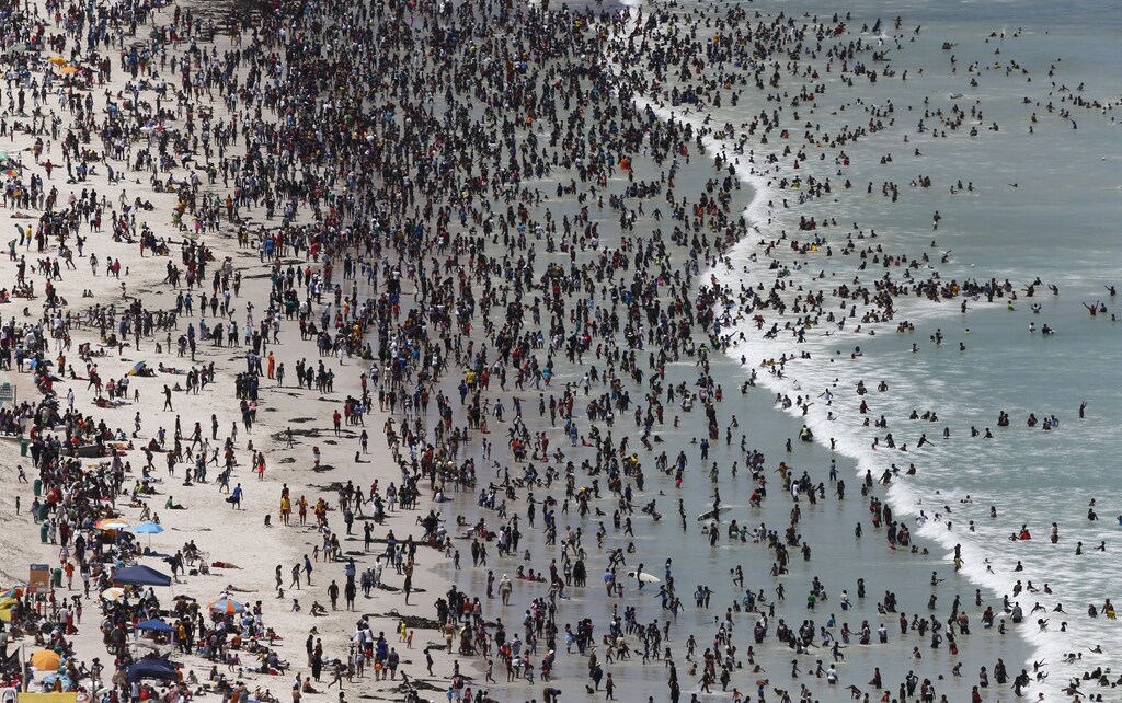 Thousands of people flock to celebrate New Year's Day on Cape Town's Muizenberg beach, January 1, 2015. REUTERS/Mike Hutchings (SOUTH AFRICA - Tags: SOCIETY) - GM1EB1204JF01