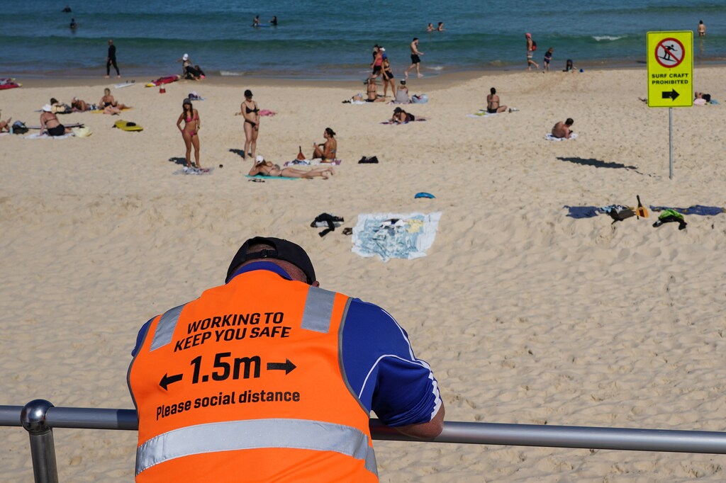 A COVID-19 social distancing marshal from Waverley Council watches over beachgoers at Bondi Beach during a lockdown to curb the spread of a coronavirus disease (COVID-19) outbreak in Sydney, Australia, September 1, 2021. REUTERS/Loren Elliott - RC2RGP9BH49L