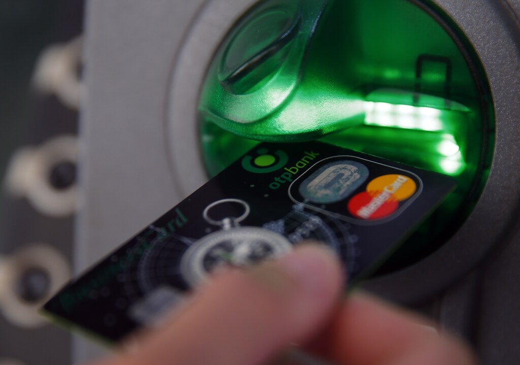 A customer performs a transaction on an ATM at a branch of Hungary's largest lender OTP Bank in central Budapest July 24, 2013. REUTERS/Laszlo Balogh (HUNGARY - Tags: BUSINESS) - RTX11X2Y