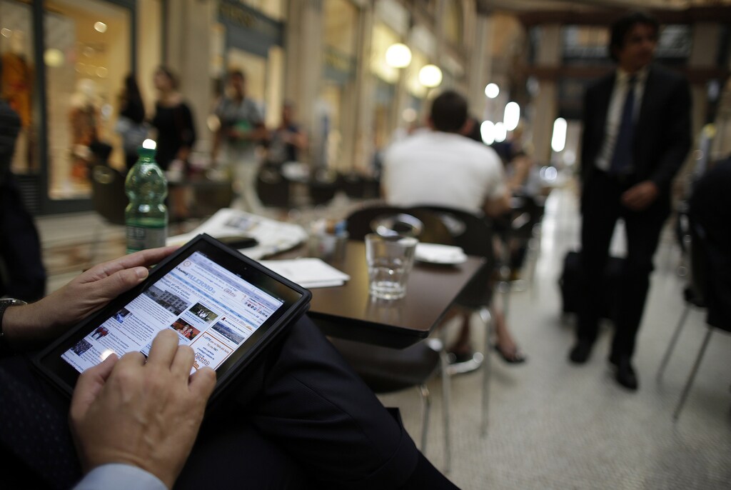 A man poses with his iPad tablet as he sits in a bar, in this photo illustration taken in Rome September 20, 2012.