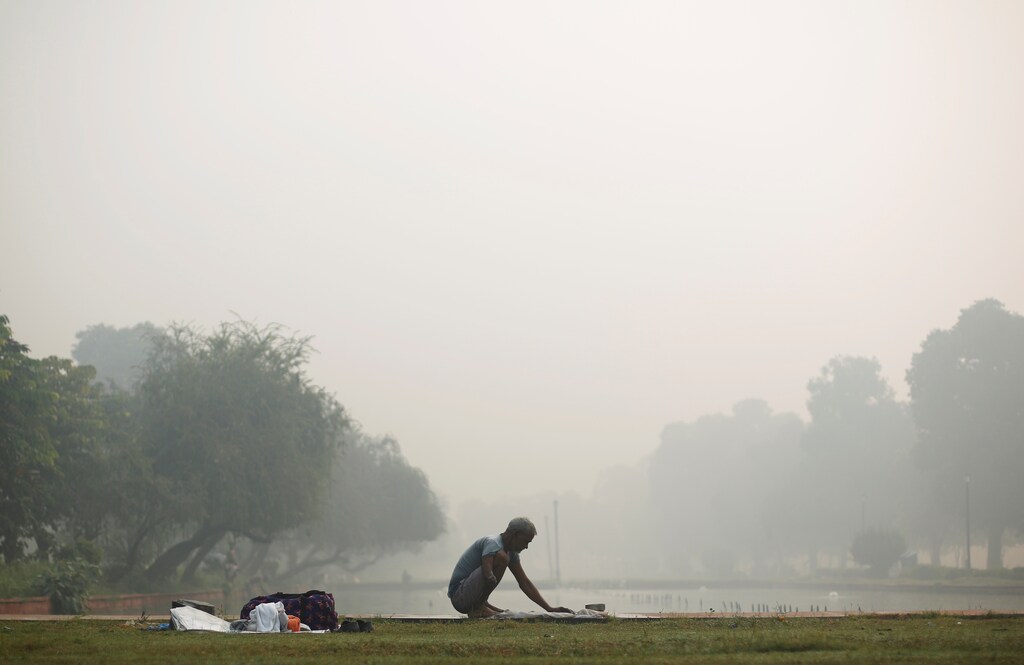 A man washes clothes at a pond near India Gate amidst the heavy smog in New Delhi, India, October 31, 2016. REUTERS/Adnan Abidi - RTX2R4NK