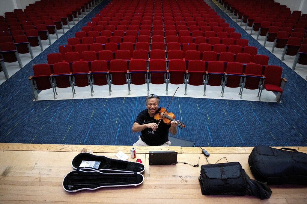 Fourth and Fifth grade music teacher Virgilio Joven plays the violin while teaching a virtual music class, amid the coronavirus disease (COVID-19) pandemic, at the Mount Vernon Community School in Alexandria, Virginia, U.S., March 2, 2021. REUTERS/Tom Brenner TPX IMAGES OF THE DAY - RC293M9WIJDF