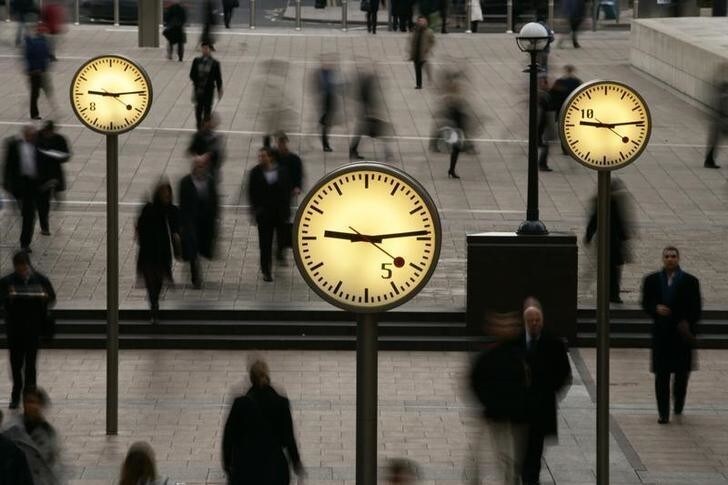 People walk past clocks at reuters Plaza in London. Canadian publisher Thomson Corp. is in talks to buy Reuters Group Plc for about 8.6 billion pounds ($17 billion) to create the world's biggest financial news and data company, the two companies said on May 1, 2007.REUTERS/Jon Jones/Handout