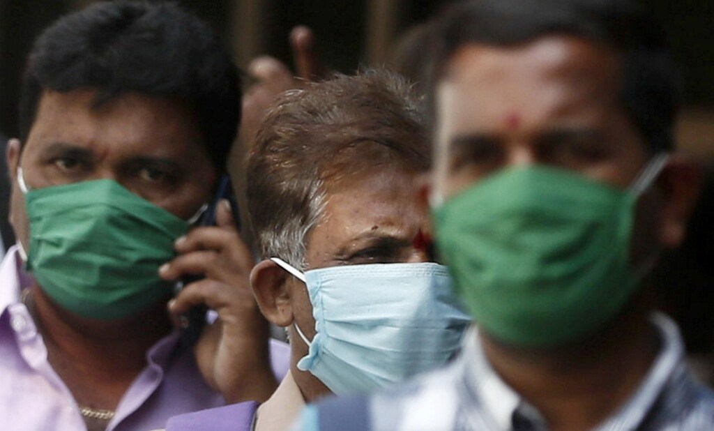 Men wearing protective masks walk inside the premises of a hospital where a special ward has been set up for the coronavirus disease in Mumbai, India, March 17, 2020.