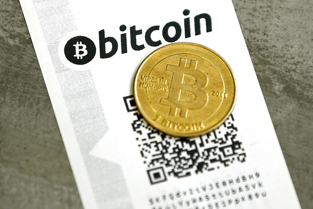 A Bitcoin (virtual currency) paper wallet with QR codes and a coin are seen in an illustration picture taken at La Maison du Bitcoin in Paris, France, May 27, 2015. British authorities have come out in support of digital currencies in the name of promoting financial innovation, while proposing that regulations should be drawn up to prevent their use in crime. But it is technophiles who are leading the drive to make London a real-world hub for trade in web-based "cryptocurrencies", of which bitcoin is the original and still most popular. Picture taken May 27, 2015. REUTERS/Benoit Tessier - PM1EB5R1DKM01