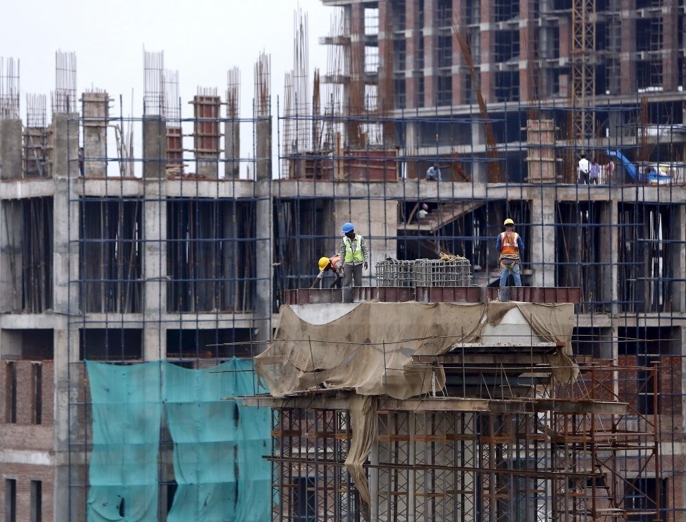 Labourers work at the construction site of a residential complex on the outskirts of New Delhi, India, June 3, 2015. Investors are hoping that Indian Prime Minister Narendra Modi's economic reforms and aggressive spending on infrastructure will take the under achieving economy to another level.