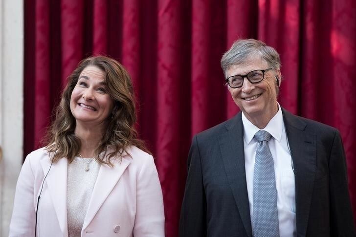 Philanthropist and co-founder of Microsoft, Bill Gates (L) and his wife Melinda laugh as they listen to the speech by French President Francois Hollande, prior to being awarded Commanders of the Legion of Honor at the Elysee Palace in Paris, France, April 21, 2017. REUTERS/Kamil Zihnioglu/Pool