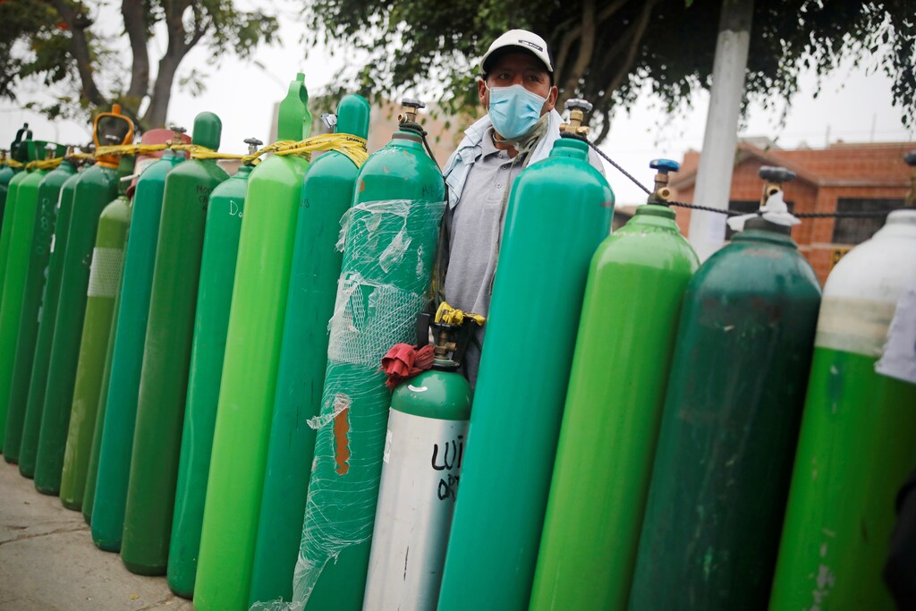 A man stands next to empty oxygen tanks to save a spot in the queue, as the supplier refills a tank per person and attends only up to 60 people a day, during the outbreak of the coronavirus disease (COVID-19), in Callao, Peru February 4, 2021. Picture taken February 4, 2021. REUTERS/Sebastian Castaneda - RC2OML9B317B