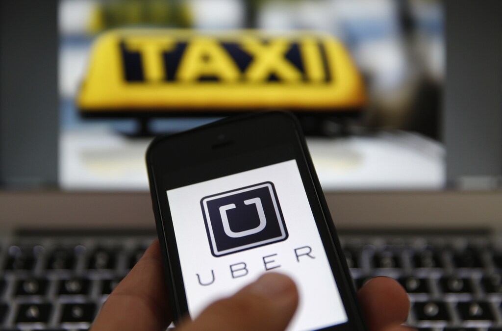 An illustration picture shows the logo of car-sharing service app Uber on a smartphone.