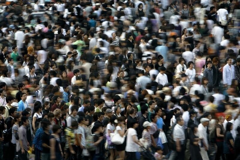 People walk across a street in Tokyo July 12, 2009. REUTERS/Stringer (JAPAN BUSINESS SOCIETY) - RTR25VH9