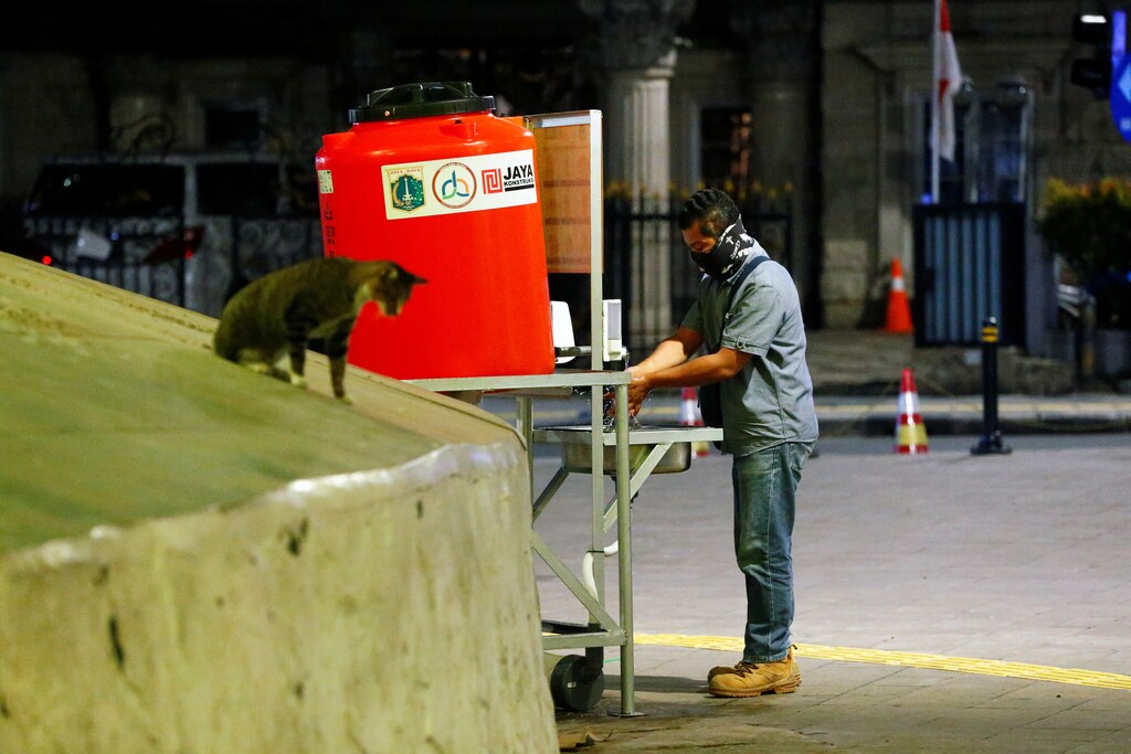 A man washes hands at a hand-washing station to prevent the spread of coronavirus disease (COVID-19) in Jakarta, Indonesia, March 26, 2020. REUTERS/Ajeng Dinar Ulfiana - RC2PRF9F7MS9