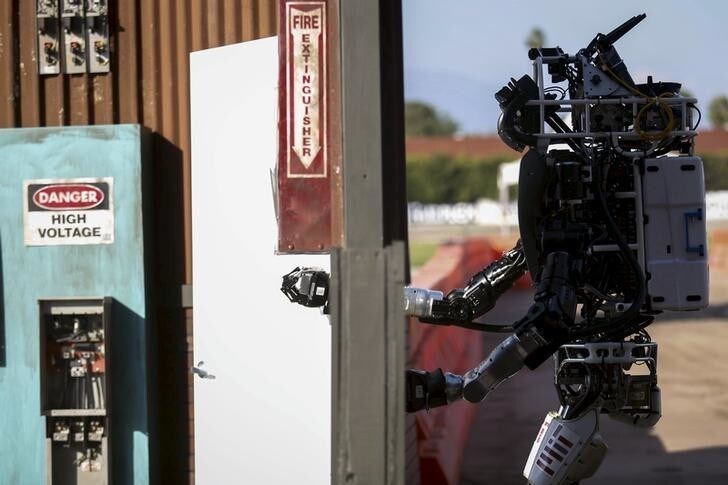 The Team MIT Atlas robot "Helios" built by Boston Dynamics opens a door during the finals of the Defense Advanced Research Projects Agency (DARPA) Robotic Challenge in Pomona, California June 6, 2015. Twenty-four teams are competing to win a portion of a $3.5 million prize by operating humanoid robots across a task and obstacle course. REUTERS/Patrick T. Fallon