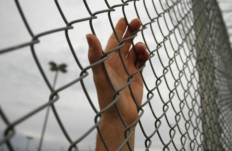 An inmate serving a jail sentence rests his hand on a fence at Maricopa County's Tent City jail in Phoenix July 30, 2010. The controversial jail is run by Maricopa County Sheriff Joe Arpaio, who supports Arizona's new illegal immigration Senate Bill 1070 law. The jail is known for housing illegal immigrants who are caught living in Arizona without proper legal documents. Picture taken July 30, 2010. REUTERS/Joshua Lott (UNITED STATES - Tags: SOCIETY POLITICS CRIME LAW) - RTR2GX0O