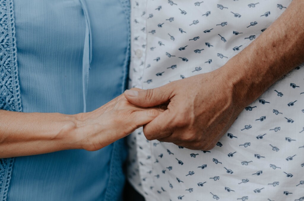 two older people holding hands