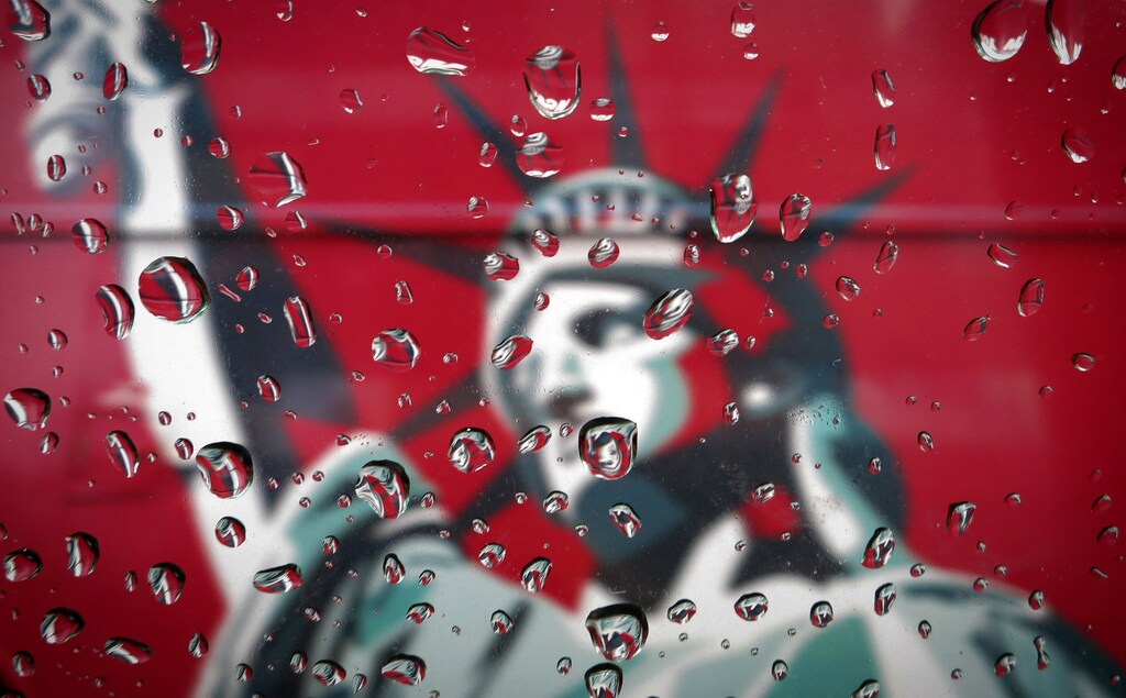 An image of the Statue of Liberty is pictured though a rain covered taxi window in New York April 15, 2014. REUTERS/Carlo Allegri (UNITED STATES - Tags: SOCIETY TPX IMAGES OF THE DAY) - GM1EA4G0B6X01