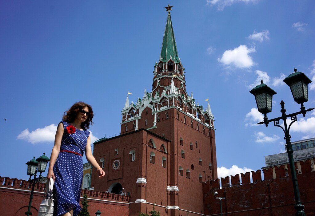 A woman walks at Alexandrovsky Garden as the Troitskaya (Trinity) Tower of Kremlin is seen in the background, in Moscow, Russia, June 30, 2016.