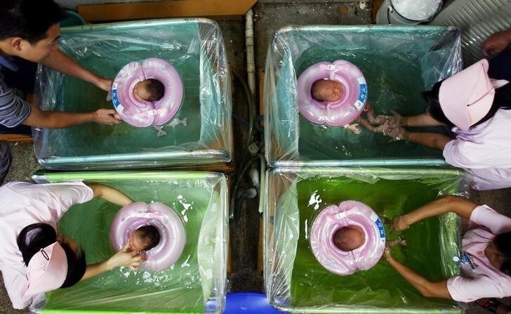 Newborn babies are given baths by a parent and nurses at a hospital in Wuhan, capital of central China's Hubei province August 19, 2006. CHINA OUT REUTERS/Stringer (CHINA)
