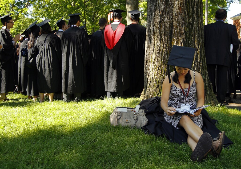 Graduating student Jennifer Lim sits in the shade before the start of the 361st Commencement Exercises at Harvard University in Cambridge, Massachusetts May 24, 2012. REUTERS/Brian Snyder (UNITED STATES - Tags: EDUCATION) - RTR32KVN
