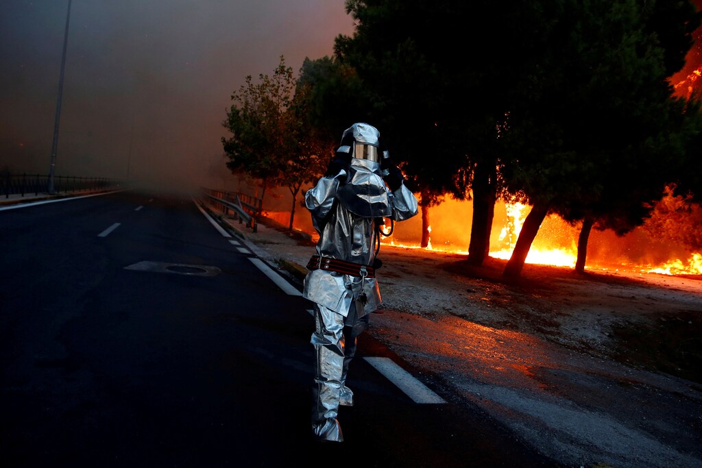 A firefighter wears a flame resistant uniform as wildfire burns in the town of Rafina, near Athens, Greece, July 23, 2018. REUTERS/Costas Baltas SEARCH "POY GLOBAL" FOR FOR THIS STORY. SEARCH "REUTERS POY" FOR ALL BEST OF 2018 PACKAGES. TPX IMAGES OF THE DAY. - RC132F0E53B0