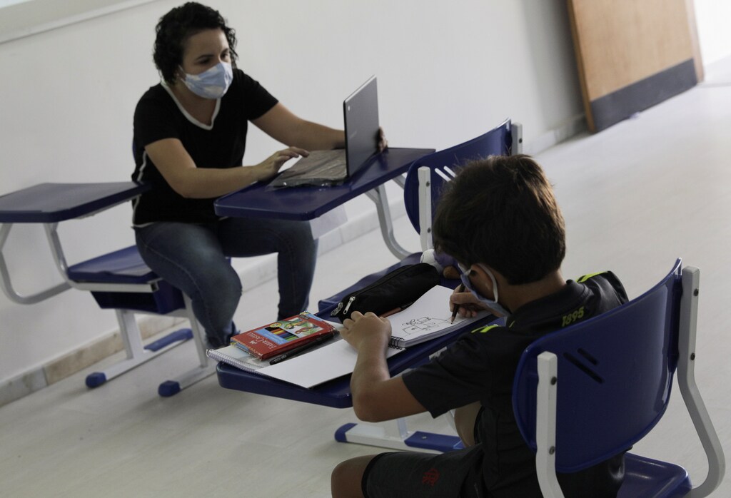 A student of Nova Escola school attends a class as his teacher talks to his colleagues studying on-line from their homes during the first day of the return of private schools in Rio de Janeiro, amid the outbreak of the coronavirus disease (COVID-19), Brazil, September 14, 2020. REUTERS/Ricardo Moraes - RC2JYI9Q2L6T